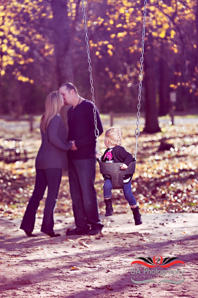 Young couple at the playground and their toddler's curiosity