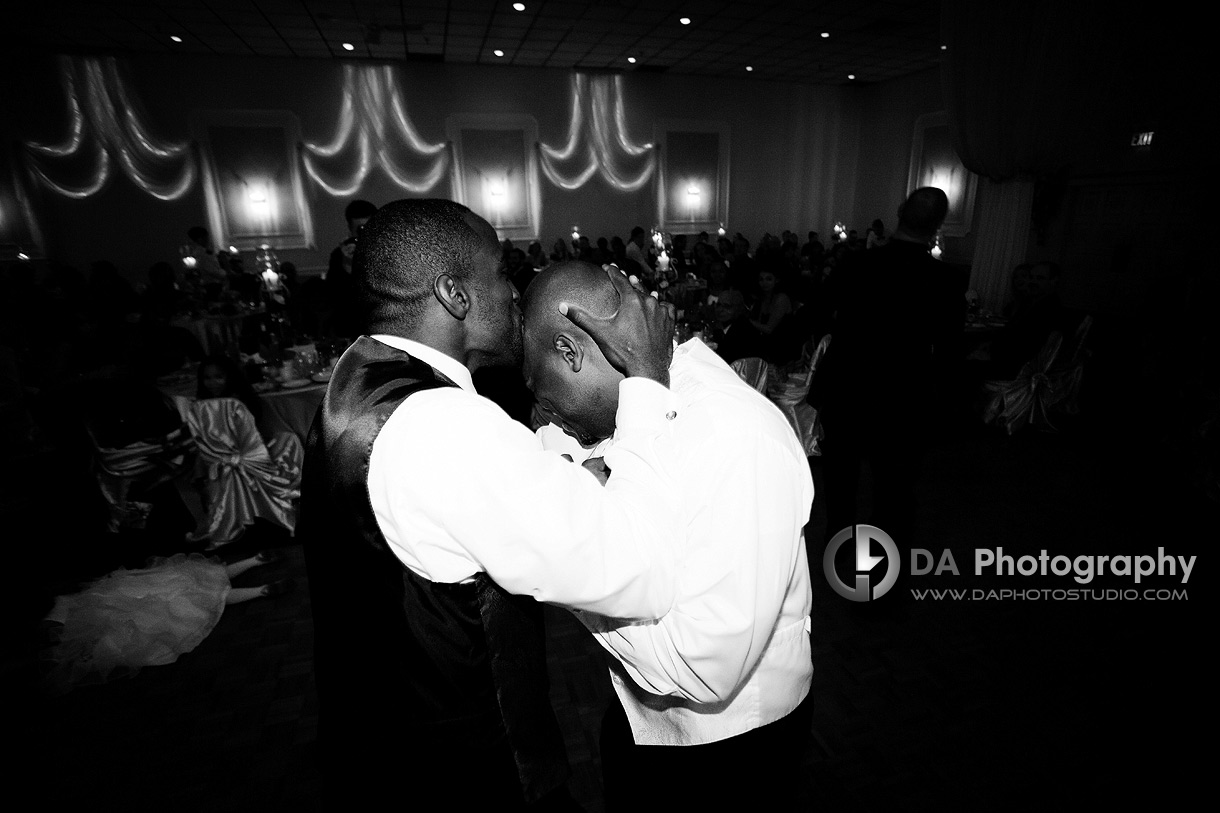 Groomsman and the groom having fun at the reception in black and white