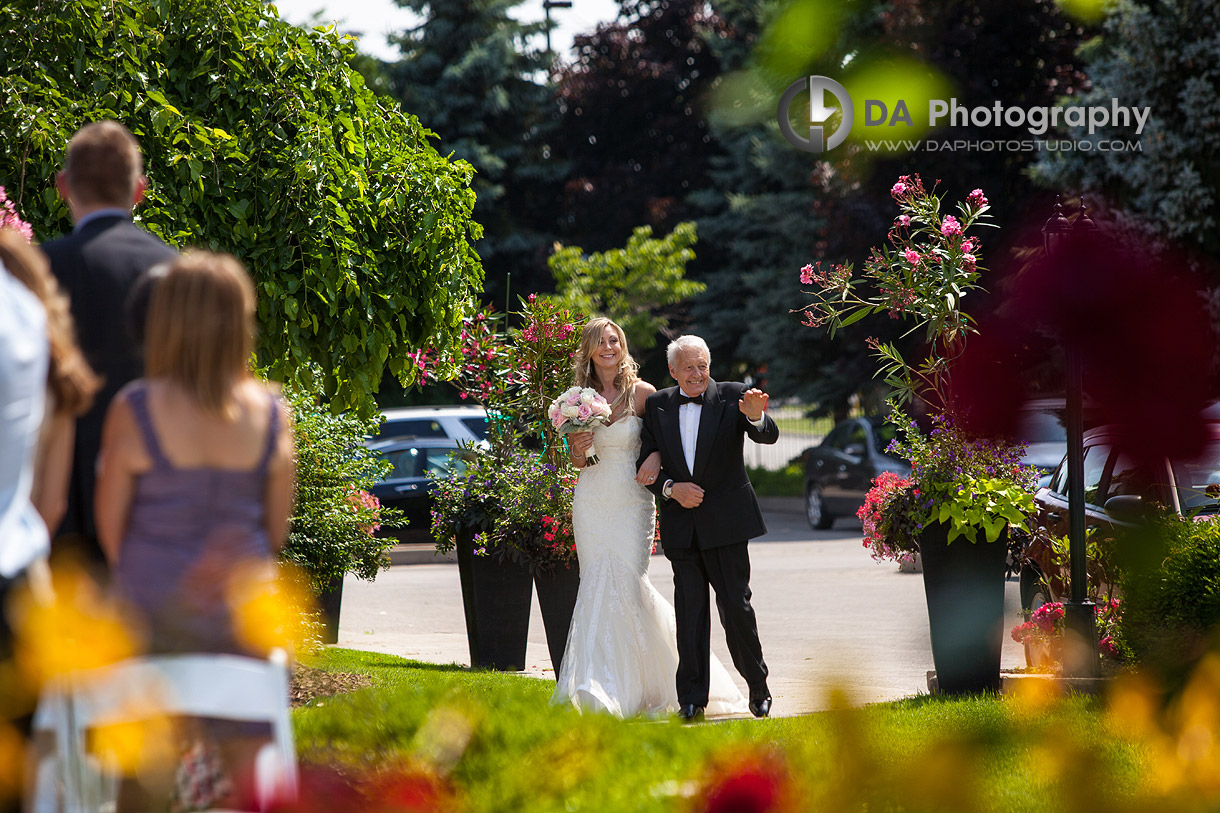 Bride Entering Outdoor Ceremony - Wedding Photography by DA Photography - Edgewater Manor - Stoney Creek, ON