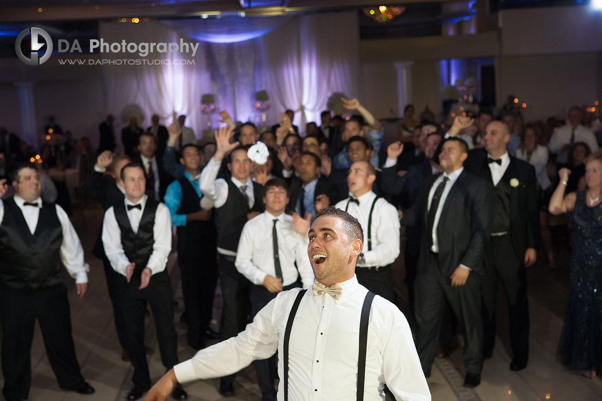 Groom tossing wedding garter - Wedding Photography by Dragi Andovski at Erchelss Estate, Oakville