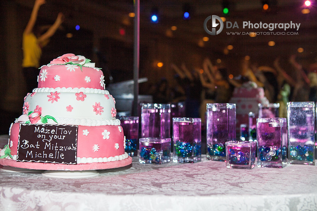 Bat Mitzvah's cake with a party in the background - Bat Mitzvah by DA Photography, www.daphotostudio.com