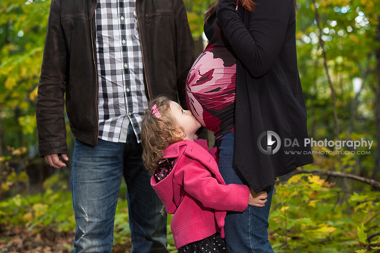 Little girl kissing the baby in mommy's belly - at Heart Lake Conservation Area by DA Photography - www.daphotostudio.com