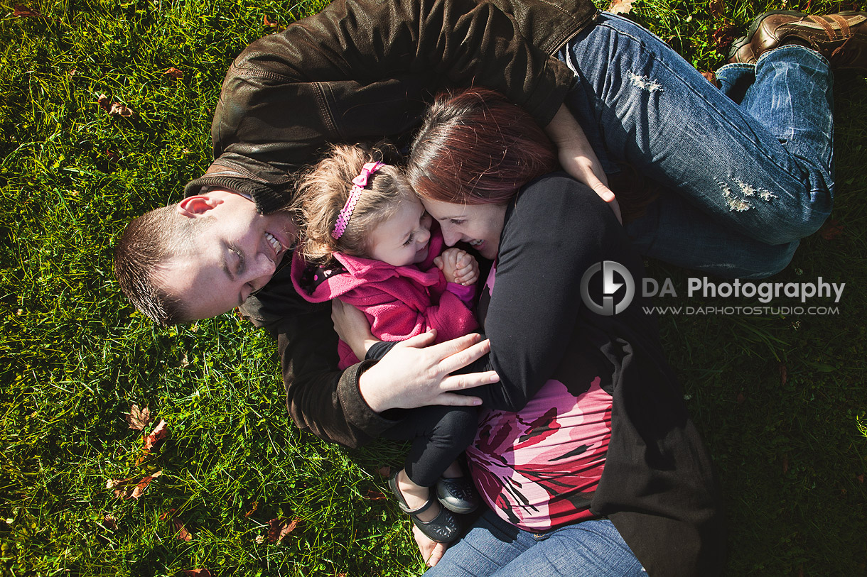 Young family in Fall laying at the grass and having fun - at Heart Lake Conservation Area by DA Photography - www.daphotostudio.com