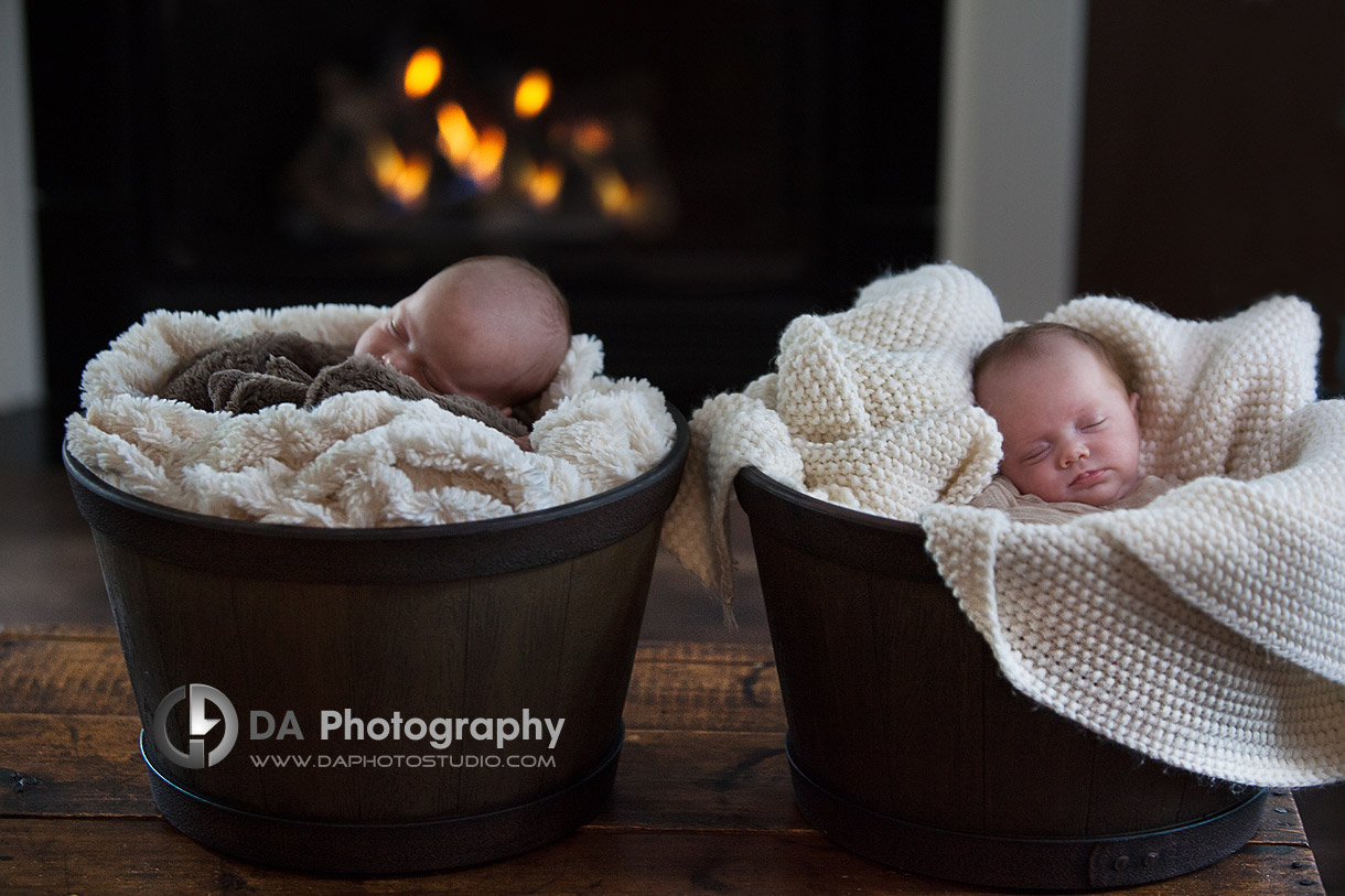 Twin newborn sisters by a fireplace -Newborn babies by DA Photography - www.daphotostudio.com