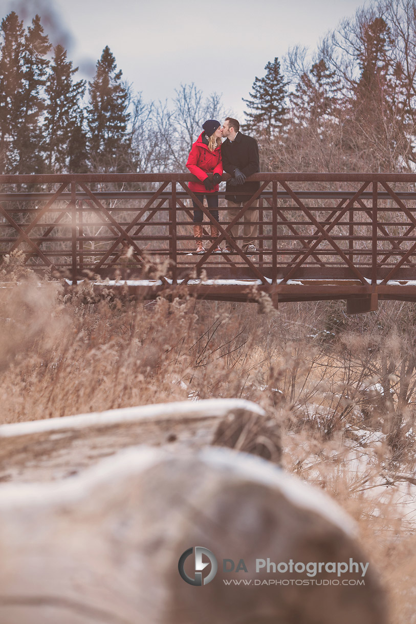 A kiss on the bridge in winter - Winter Engagement photo shoot by DA Photography, www.daphotostudio.com