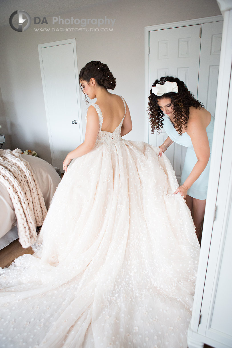 Bride is getting help by her mom on a wedding day