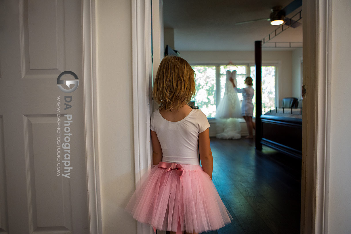 Flower girl watching the bride how is looking at her wedding dress