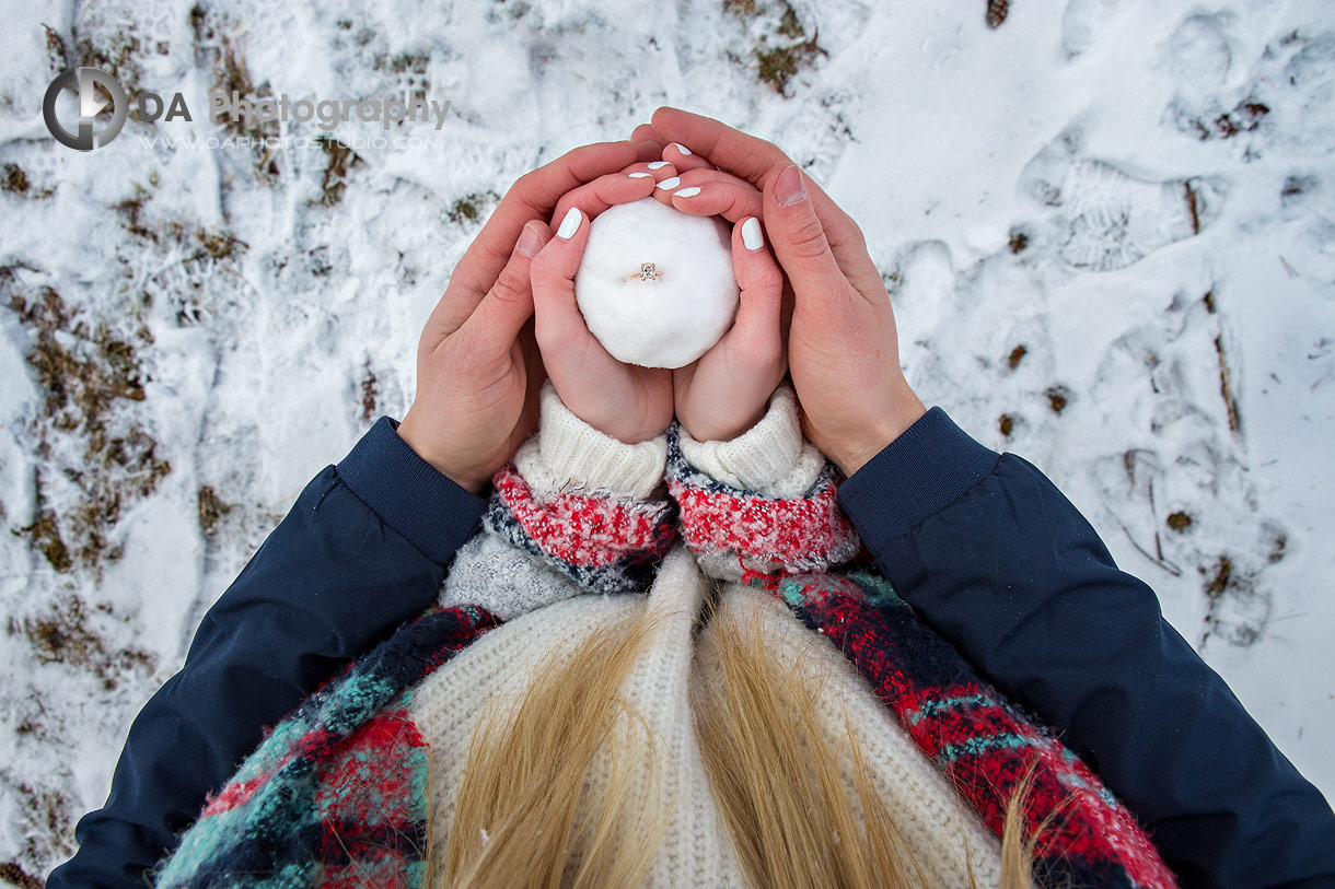 Flat shot of a Engagement ring in a snow ball held by the couple