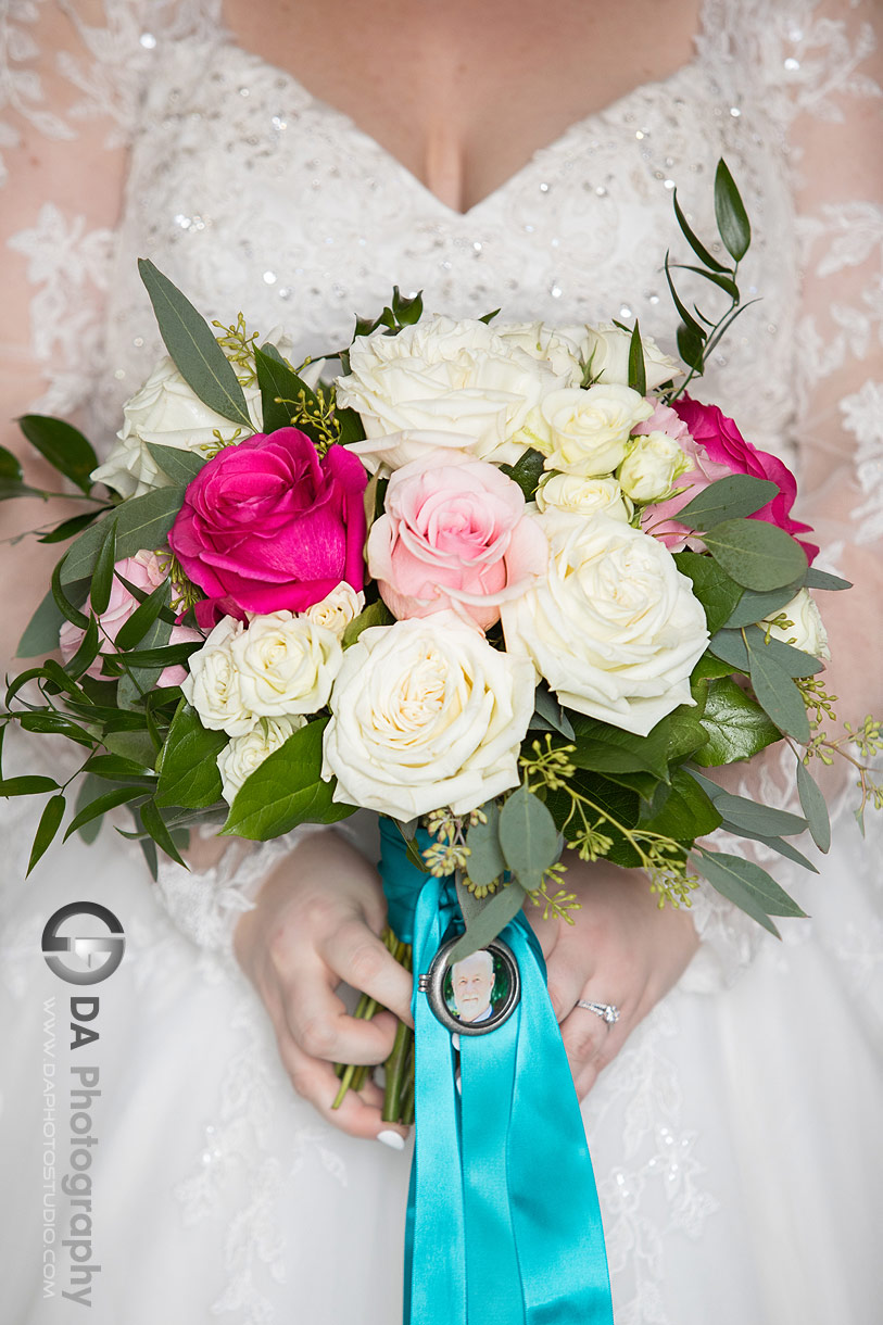 Close up photo of a wedding flowers with a pendant of bride's father picture