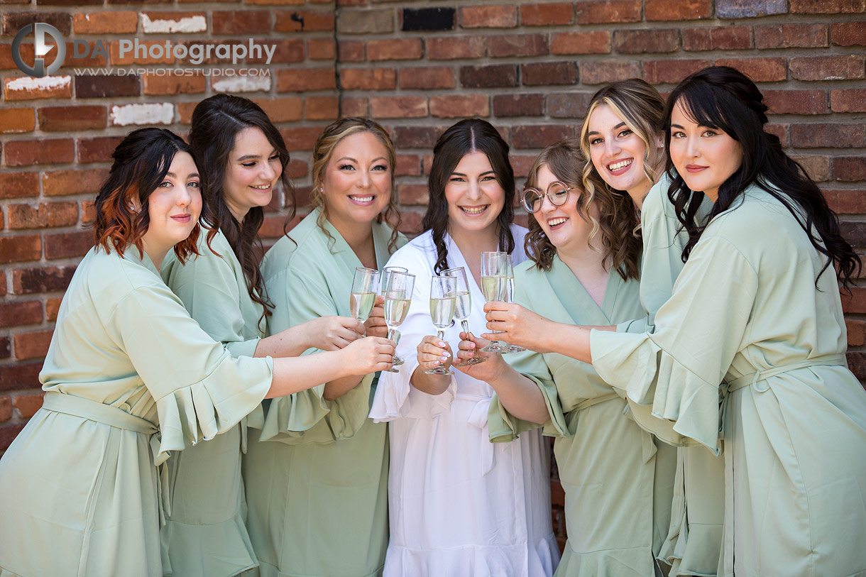 Bride with her bridesmaids having champagne is their robes