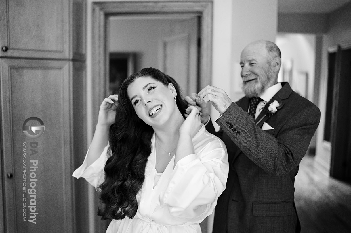 Photo of a dad helping his daughter putting the earrings